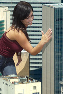 giantess collage clothed brunette smiling hand skyscraper denise_milani between_buildings rooftop_view