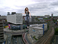 giantess collage clothed shoes brunette smiling wonderslug walking clouds sky clothing between_buildings cheryl_tweedy_cole
