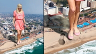 crush city mega beach smiling celebrity phone legs looking_down waves foot_print sunglasses paris_hilton pink_dress sunny pink_shoes xcalibur stepping_down
