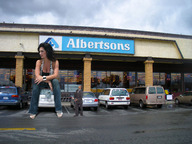 giantess collage small_man size_difference black_hair clothed cleavage buildings wonderslug sitting parking_lot vehicle_crush store