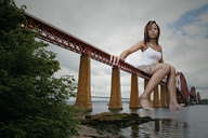 giantess collage bridge barefoot water low_angle sitting dark_skin sky tattoo garcia_accasbel looking_at_viewer accasbel genarika