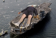collage sleeping giant ocean socks lying_down shorts sneakers ships facial_hair aircraf_carrier