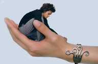 collage clothed handheld shrunken_man looking_down bracelet