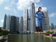 breasts giantess collage city mega brunette superhero smiling gloves boots skyscraper costume looking_at_viewer hands_on_hips blue_outfit giulio_10