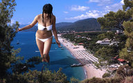 giantess black_hair large_breasts swimsuit beach water ocean buildings pigtails legs walking looking_down boats trees shadows docks beach_side