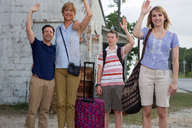 clothed amazon shorts family standing shirt waving jennifer_aniston vacation luggage