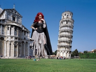 skirt buildings red_hair grass corset gothic_giantess necklace knee_high_boots bystanders leaning_tower_of_pisa devious_look hand_on_lip