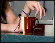 breasts gentle collage nude black_hair long_hair butt barefoot smiling hand shrunken_woman standing bracelet mug digital_render starkadhr