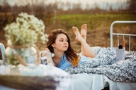 gentle collage clothed barefoot bed brunette lying_down shrunken_man outdoors stretching