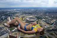 giantess collage city mega blonde long_hair clothed buildings shoes stadium lying_down shorts top water_bottle bare_midriff