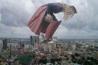 giantess collage city mega blonde long_hair destruction smiling boots supergirl bending_over looking_down laughing outdoors cape melissa_benoist