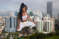 breasts giantess collage city mega black_hair large_breasts long_hair cleavage high_heels buildings ponytail sandals looking_down sunglasses dark_skin crouching earrings