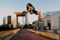 giantess collage city high_heels buildings brunette gloves unknown_artist kneeling looking_at_viewer on_roof